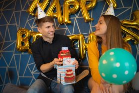 kobieta i mężczyzna cieszący się i trzymający skarpetkowy tort urodzinowy, pomysł na prezent urodzinowy od Rainbow Socks