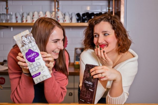 kobiety trzymające czekoladowe skarpetki w pudełku, biała czekolada, mleczna czekolada, zabawny prezent od Rainbow Socks