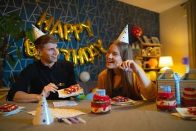 Mann und Frau feiern Geburtstag mit Geburtstagstorte Socken Box von Rainbow Socken