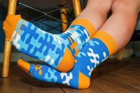 woman wearing blue and orange socks with puzzle motifs, Rainbow Socks