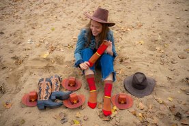 Frau trägt lange rot-braune Socken mit Wildwest-Muster, lustige Socken für Reiterin