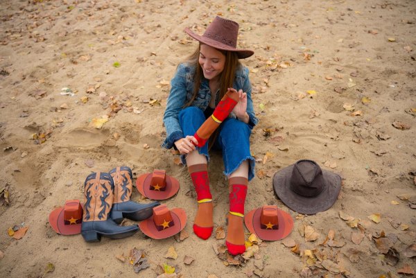 Woman wearing long red-brown socks with wild west patterns, funny socks for horse rider