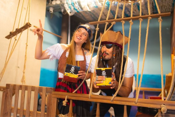 Ein Piratenpaar hält eine Kiste mit Piratenschatzsocken in den Händen, Rainbow Socken