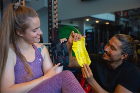 Mann und Frau halten schwarz-gelbe Sportsocken, Energy-Drink-Socken in einer Dose