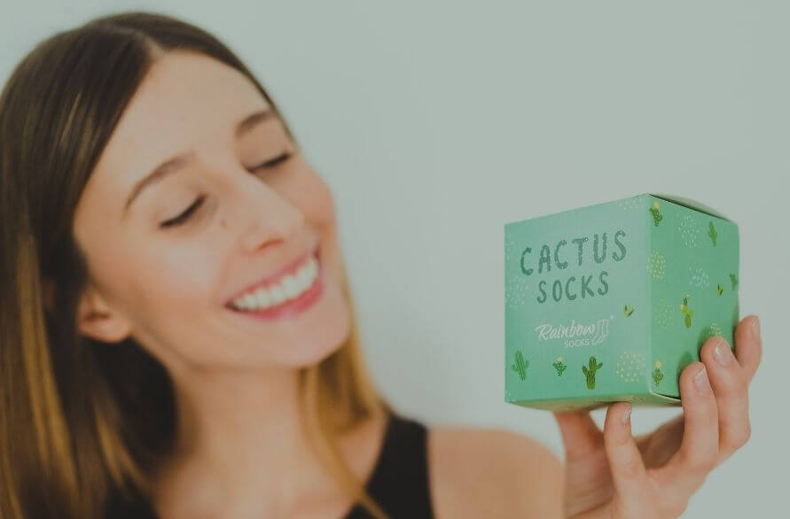 Happy woman after receiving cactus socks box