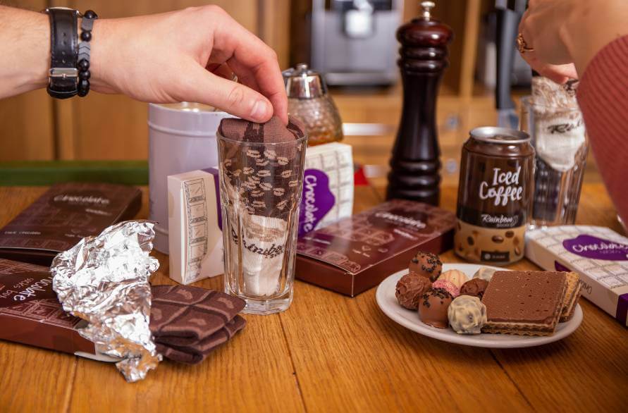 Two people at a table with chocolate and coffee socks on a table