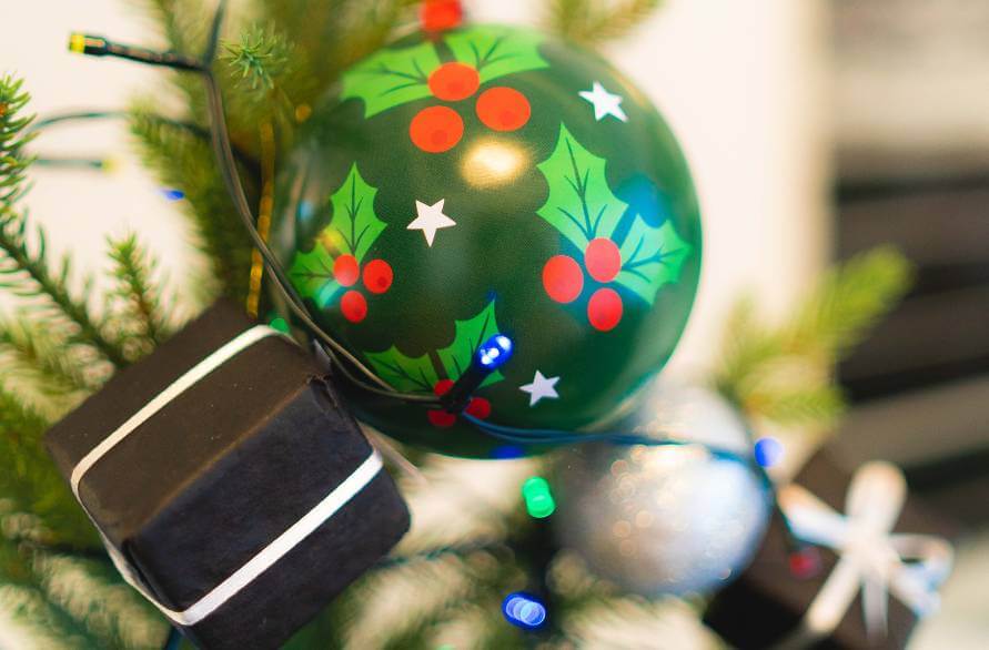 A green Christmas ball of socks on a Christmas tree.