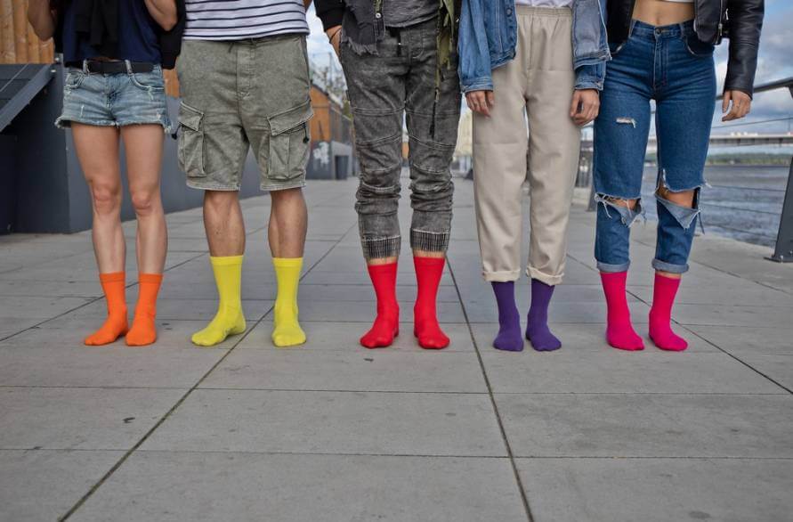 A group of five people outside wearing colourful Rainbow socks