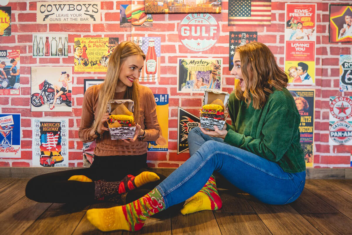 Women wearing funny and colourful socks looking like a real burger