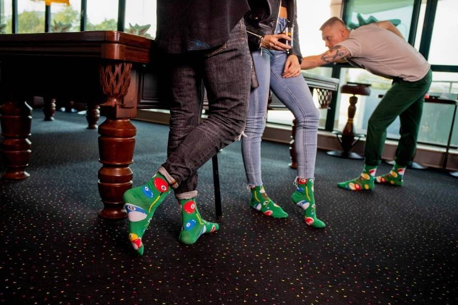 Themed Party Socks – friends playing billard in their Rainbow Fun Socks.