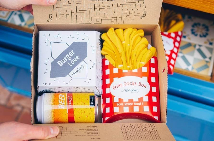 Three pairs of Fries Socks Boxes arranged like real french fries.
