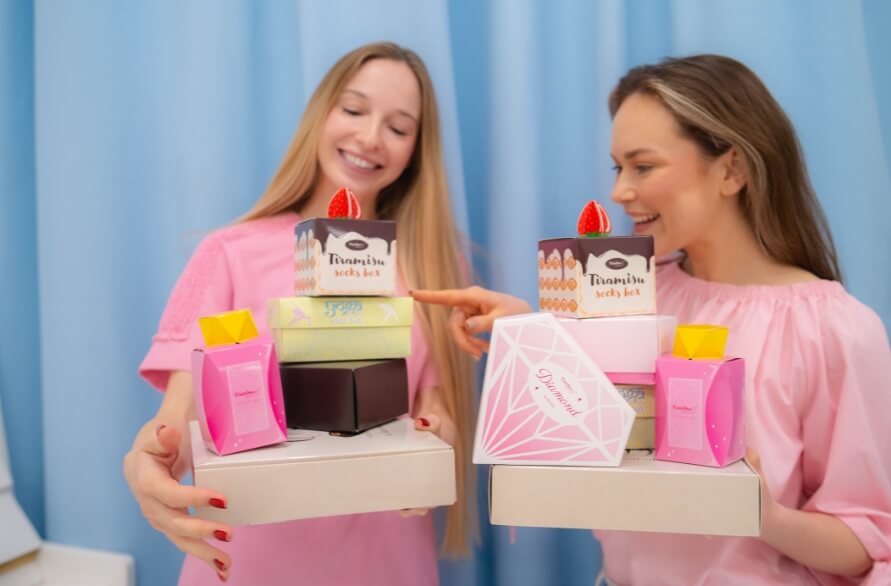 Two women holding sock gift ideas for a Women's day